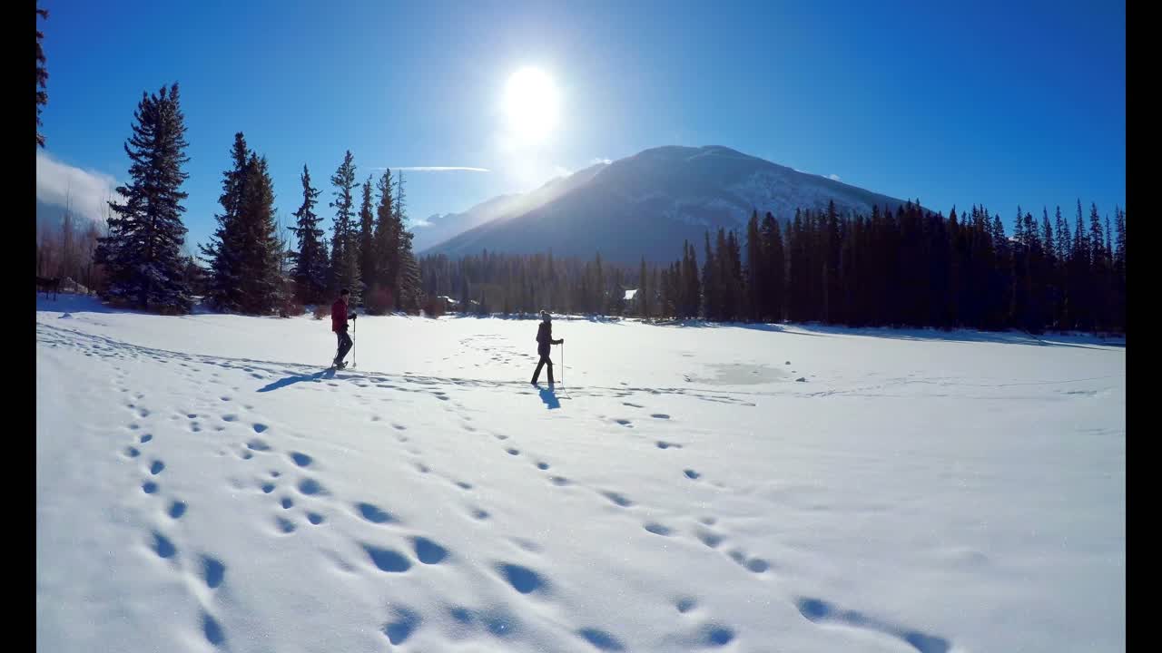 pareja de esquiadores caminando por un paisaje nevado 4k