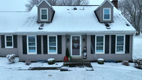 casa con techo nevado y decoraciones navideñas durante la época de navidad