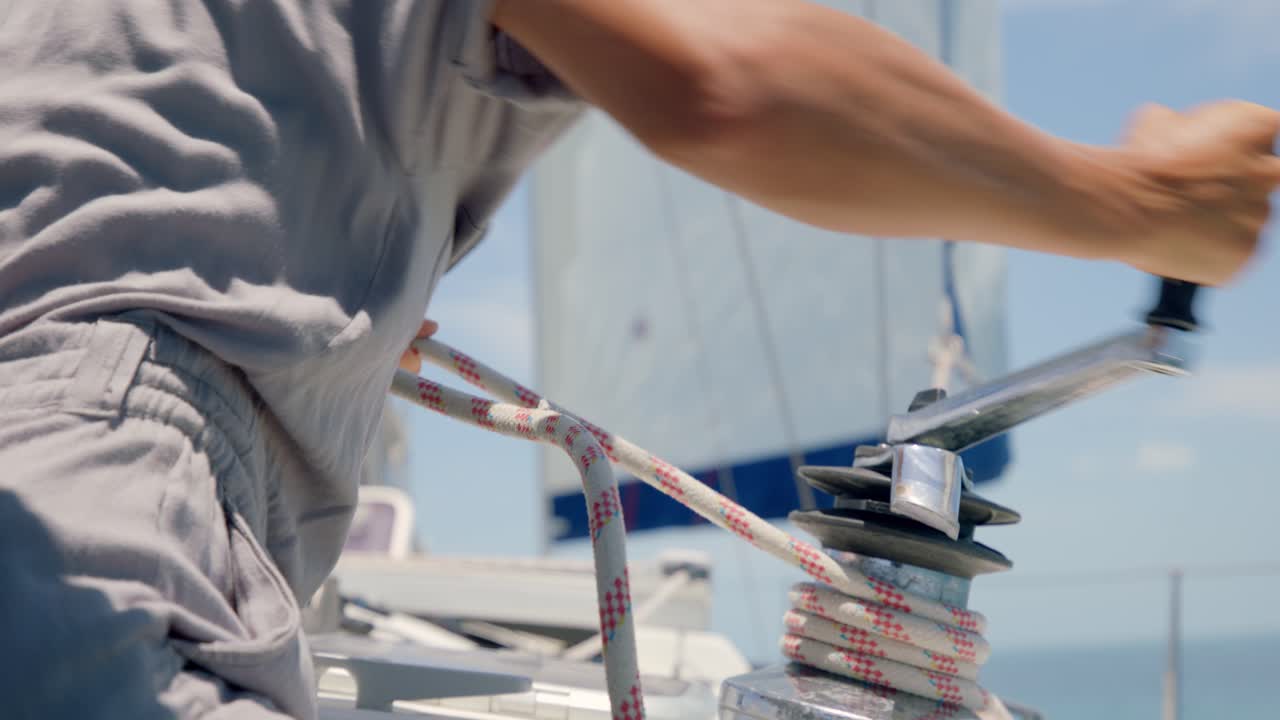 Sailor Turning Self-tailing Winch On A Sailboat By Crank. - close up