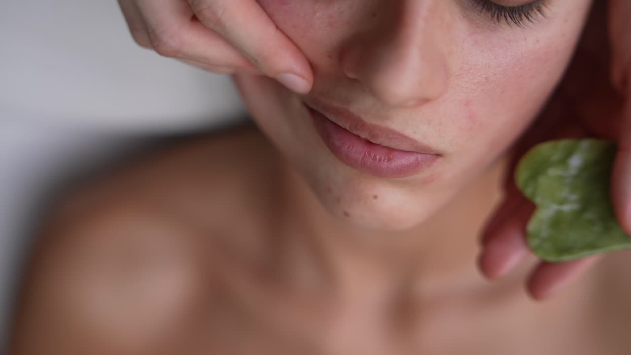 Close-up of Woman's Face During Gua Sha Facial Massage