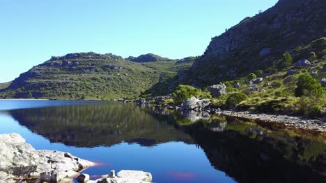 Vista-Aérea-Sobre-El-Lago-En-Las-Montañas-Durante-El-Verano