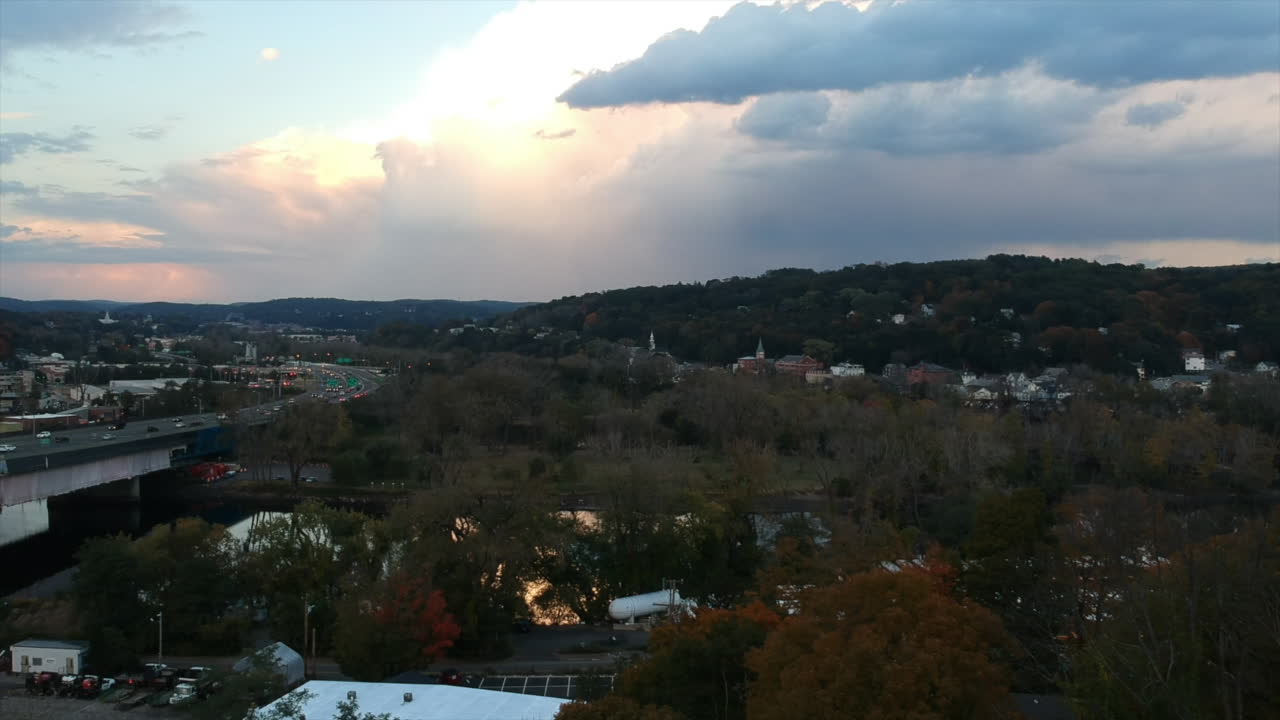 Drone view over a highway in a New England town on an autumn day at dusk