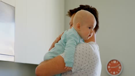 father comforting his baby boy in kitchen 4k