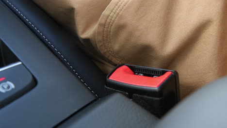 young woman fastening her safety belt in a car