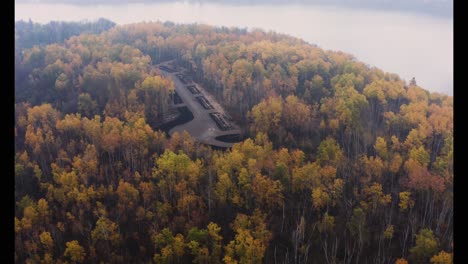 Toma-Aérea-Del-Bosque-Amarillo-Y-Rojo-A-Lo-Largo-De-Un-Río-Brumoso