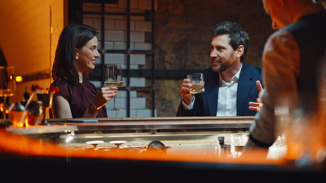 Glade par drikker alkohol tæt på i natklub. Mand flirter med kvinde