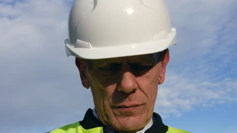 Extreme-close-up-portrait-of-an-architect-senior-building-construction-manager-on-a-residential-street-with-traffic-and-houses-looking-at-paperwork-inspecting-the-building