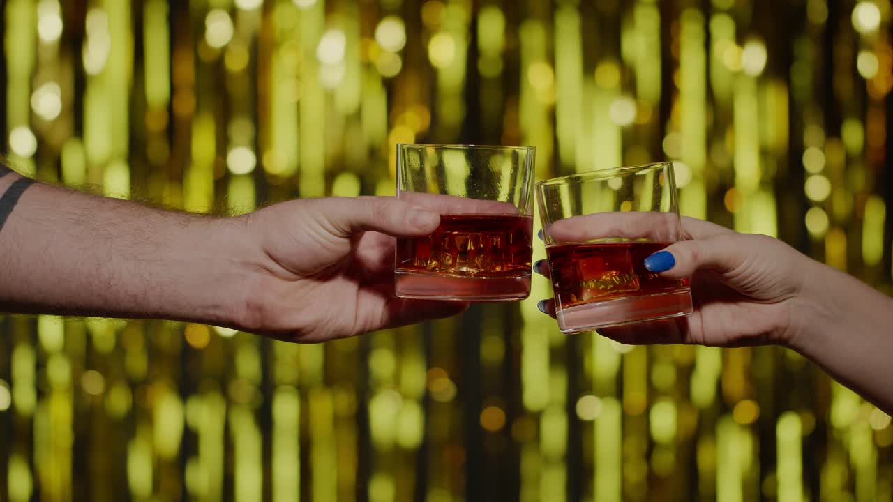 두 손은 코냐크 위스키 잔과 얼음  ⁇ 어리로 환호하고, 토스트를 올리고, 축하하고