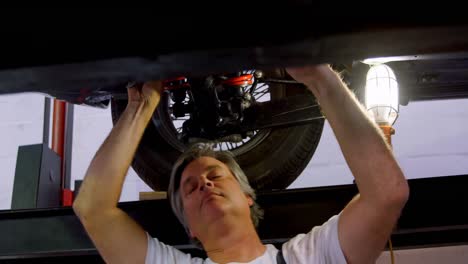 mecánico masculino haciendo servicio a un coche 4k