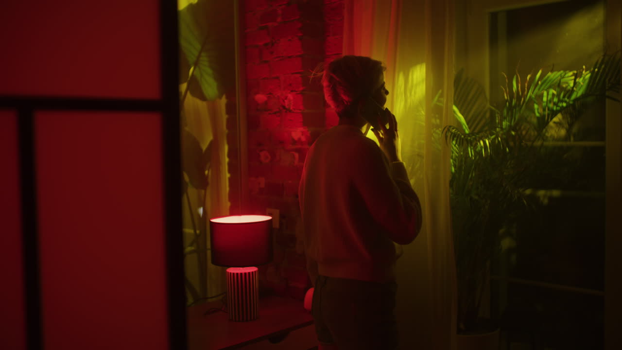 Woman Talking on Phone in a Neon-Lit Room