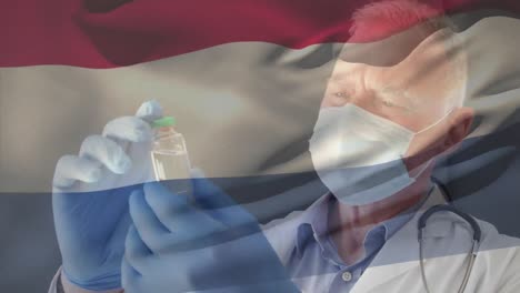 Animation-Der-Flagge-Der-Niederlande,-Die-über-Einem-Arzt-Weht,-Der-Eine-Gesichtsmaske-Trägt-Und-Einen-Impfstoff-In-Der-Hand-Hält