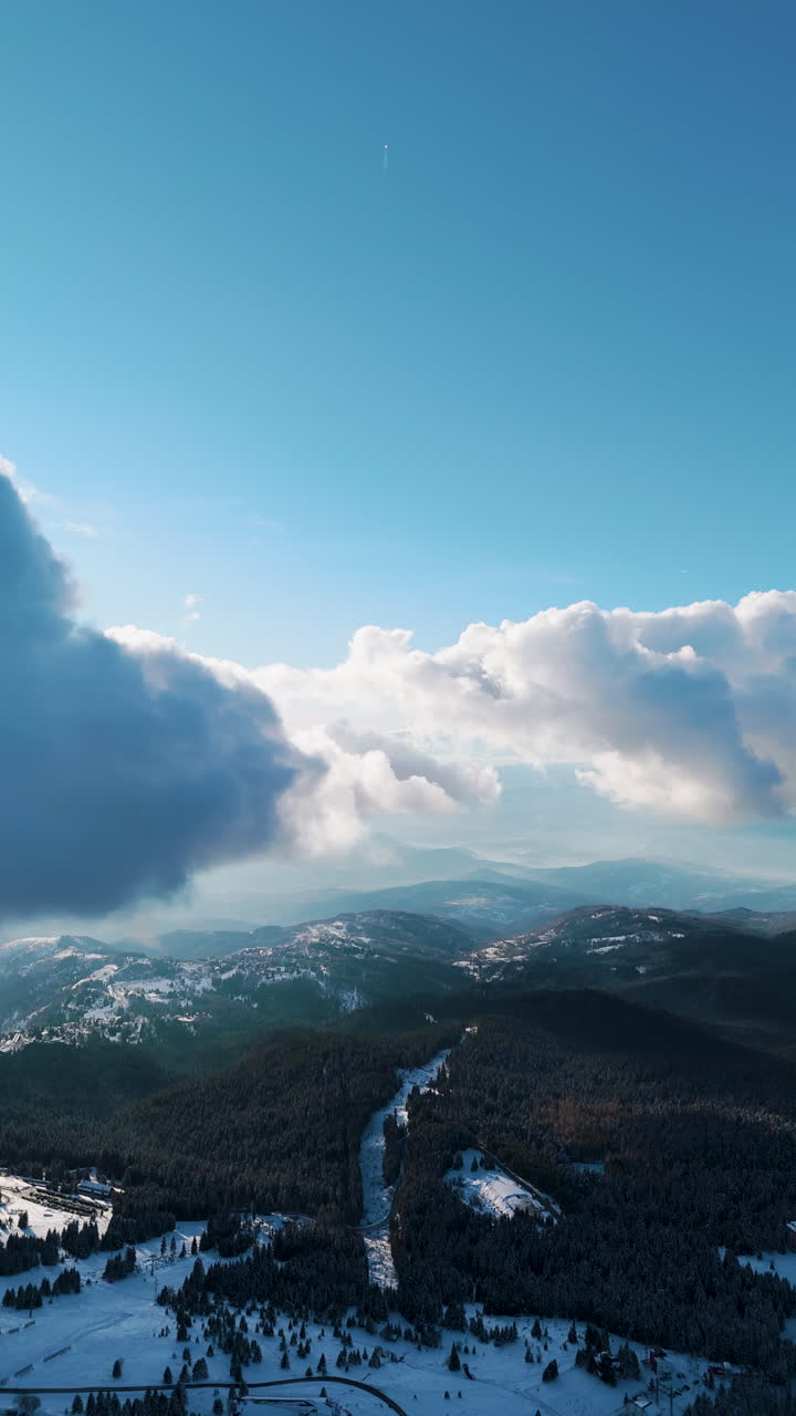 Vista panoramica mozzafiato con valli e cime di montagne innevate e cielo azzurro sullo sfondo