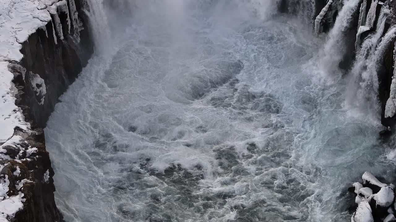 Overhead shot of icy whirlpools and rock formations at the base of Selfoss waterfall. Selfoss, Iceland