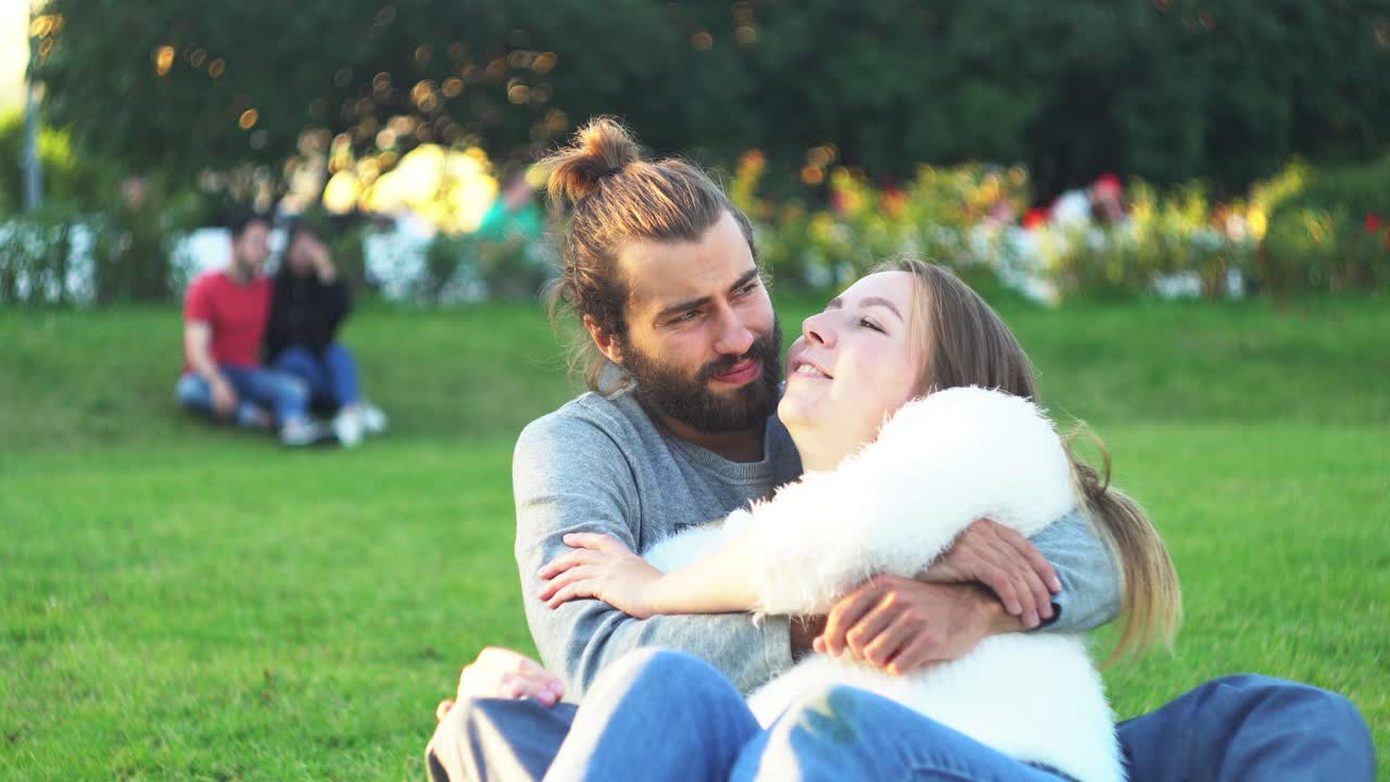una pareja besándose en un parque.
