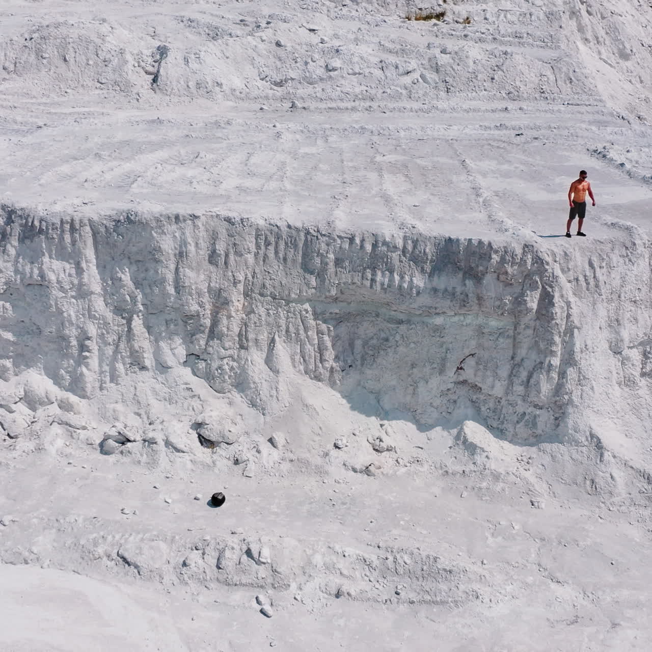 White canyon and a sportsman. View from above on strong athlete standing on the top of the hill. Aerial view.