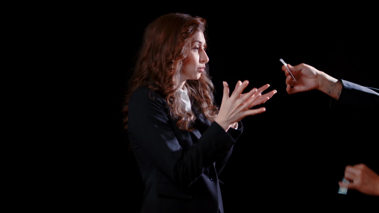 A man tears a woman's dollar bill in half