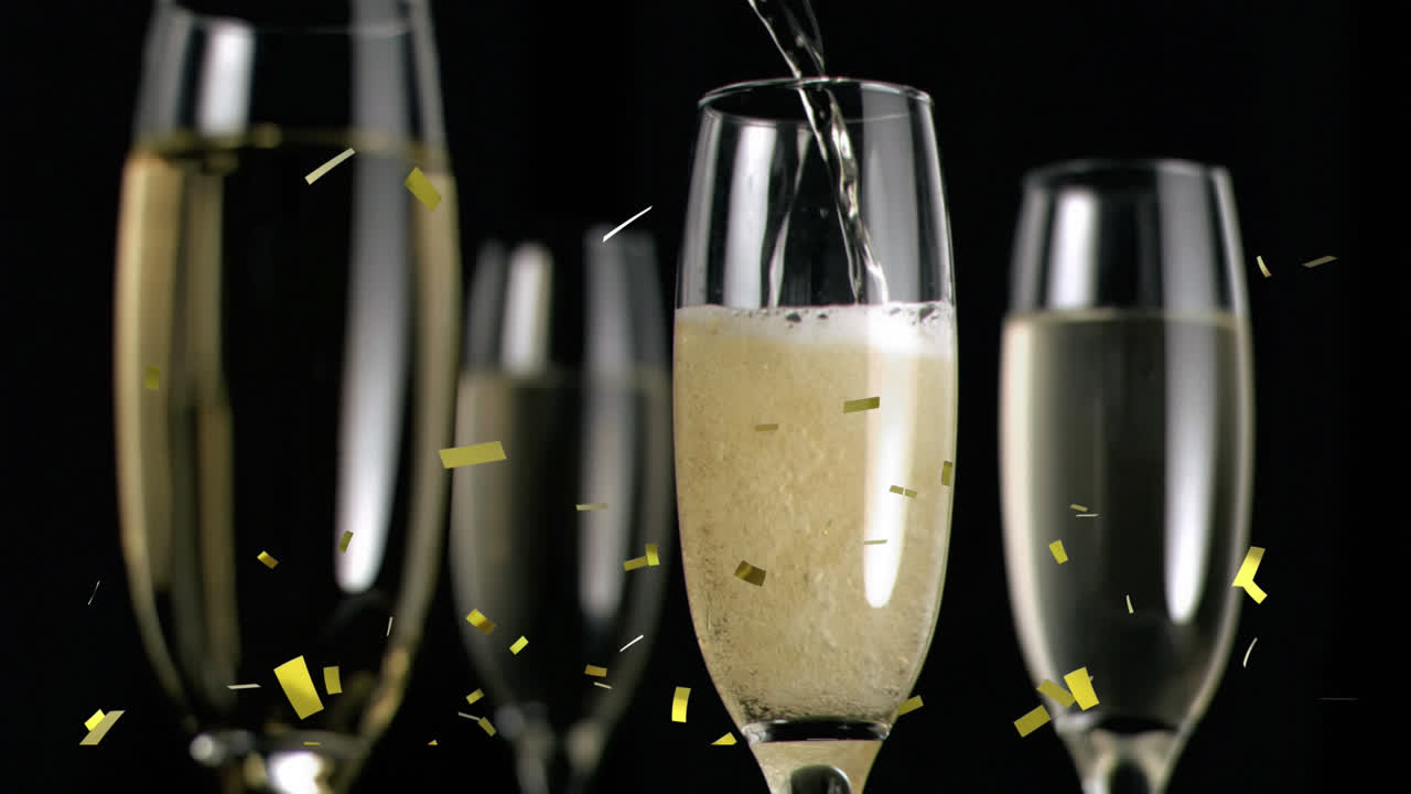Animazione di coriandoli dorati che cadono su bicchieri di champagne su sfondo nero.