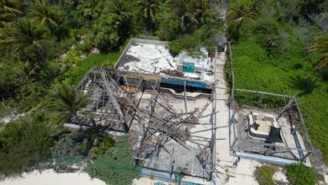 Ruins-of-beach-bar--damaged-by-tropical-hurricane-and-abandoned--Caribbean-Resort-with-palm-trees