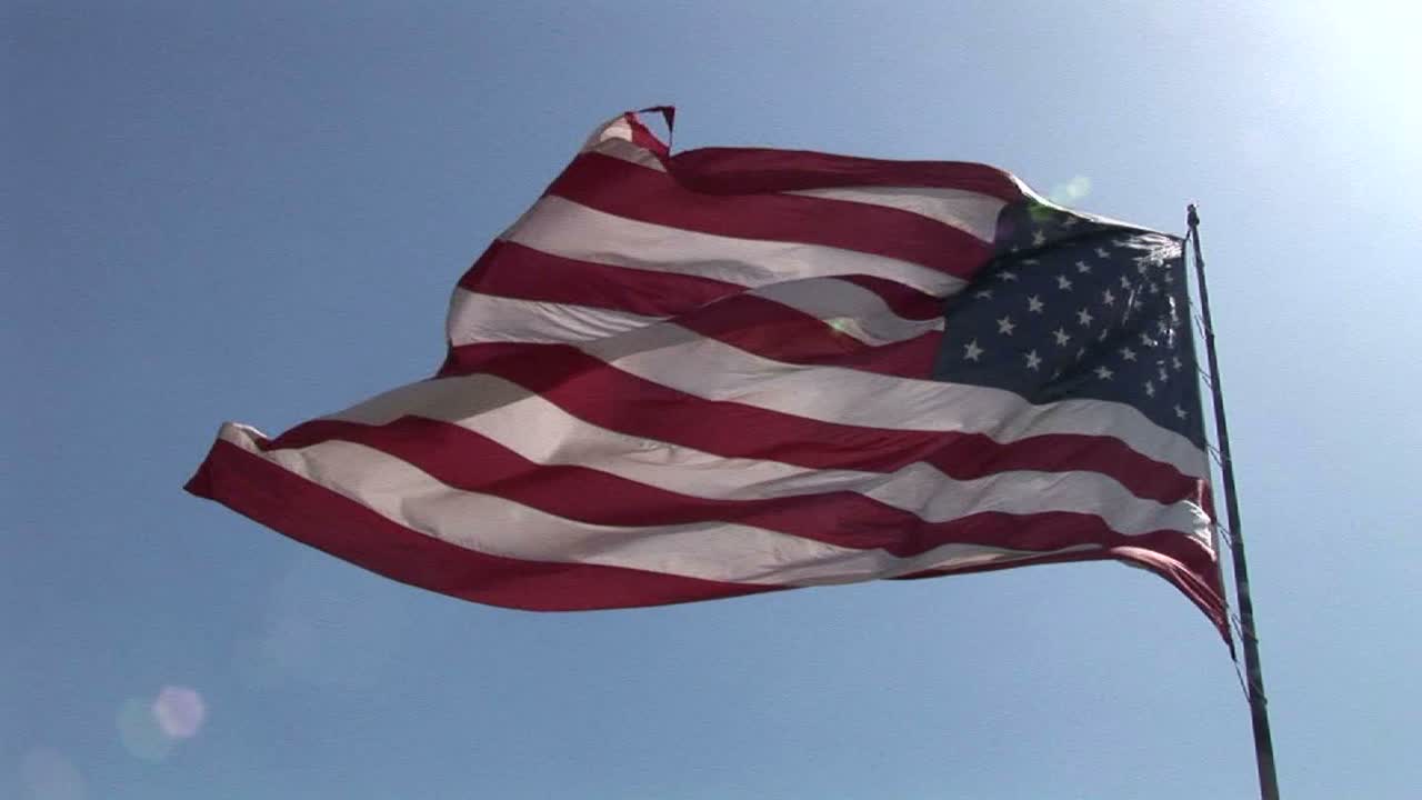 una bandera americana ondea en el viento el día 1