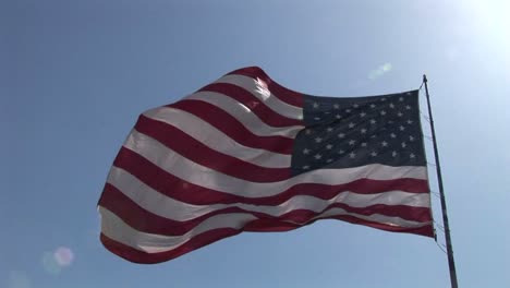 an american flag flies in the wind at day 1