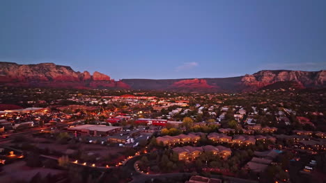 wide revealing twilight drone shot of sedona arizona with the mountains in the distance