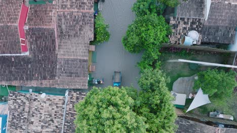 Aerial-Top-Down-Drone-View-of-rural-beach-town-Caraiva-Bahia-Brazil-rooftops-and-man-on-cart-with-horse