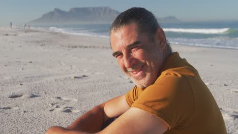 Portrait-of-a-senior-Caucasian-man-enjoying-time-on-the-beach