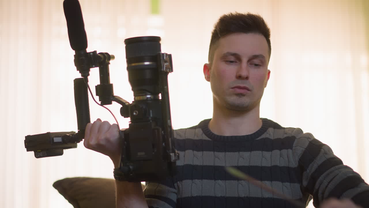 TV technician fine tuning camera equipment using a screwdriver. Person adjusts camera rig, checking lens, microphone, and setup in studio environment with green wall and lighting