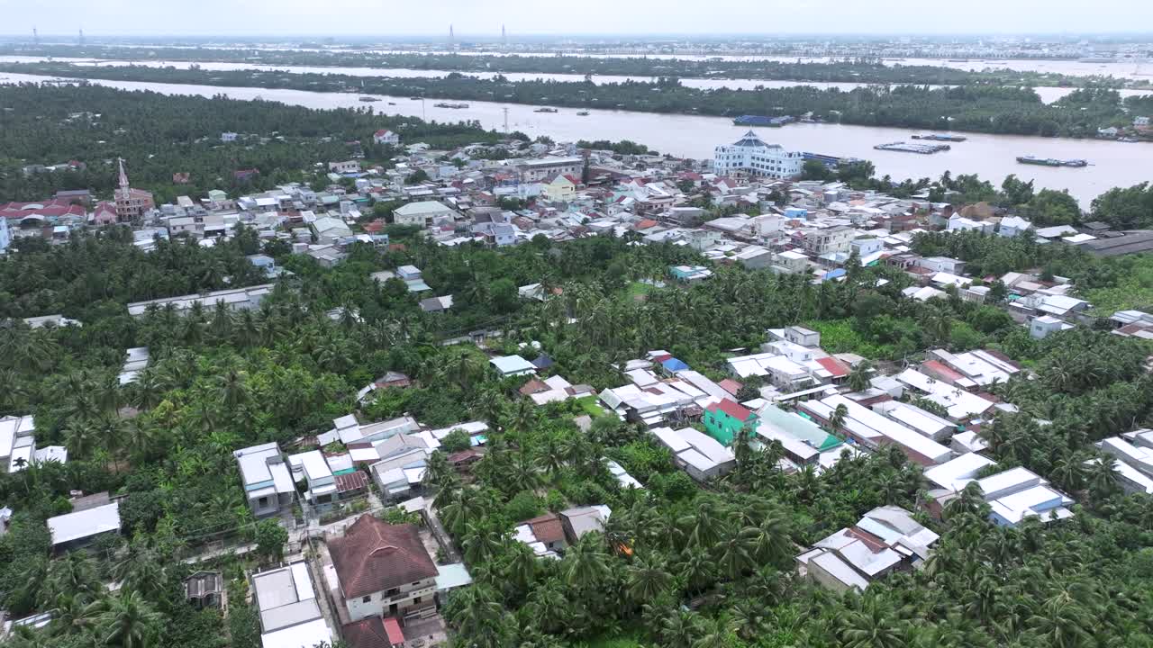Lush riverside town in Mekong Delta with dense greenery and scattered houses