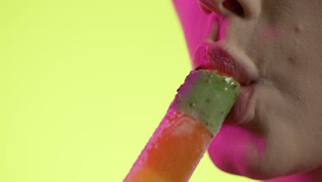 mujer tomando un bocado de un helado en primer plano, fondo amarillo