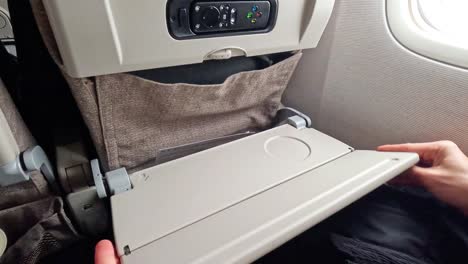 demonstrating folding airplane tray table usage