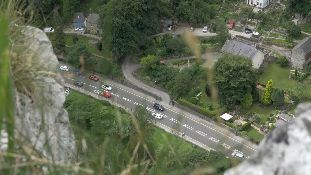 Top view of traffic at rush hour in riverside valley village. Grass foreground