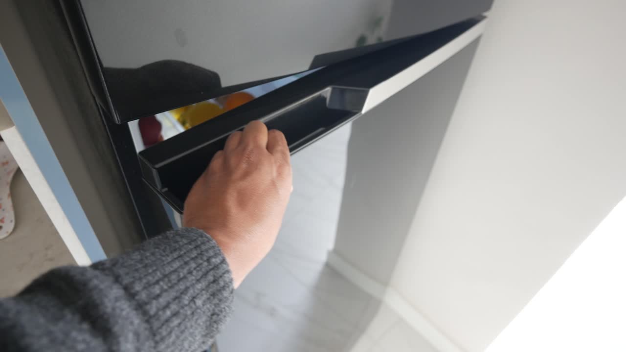 persona abriendo un refrigerador negro