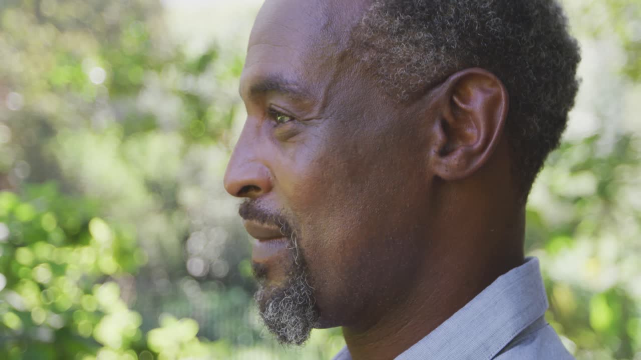 시니어 아프리카계 미국인 남자가 미소 짓고 카메라를 쳐다보고 있습니다.