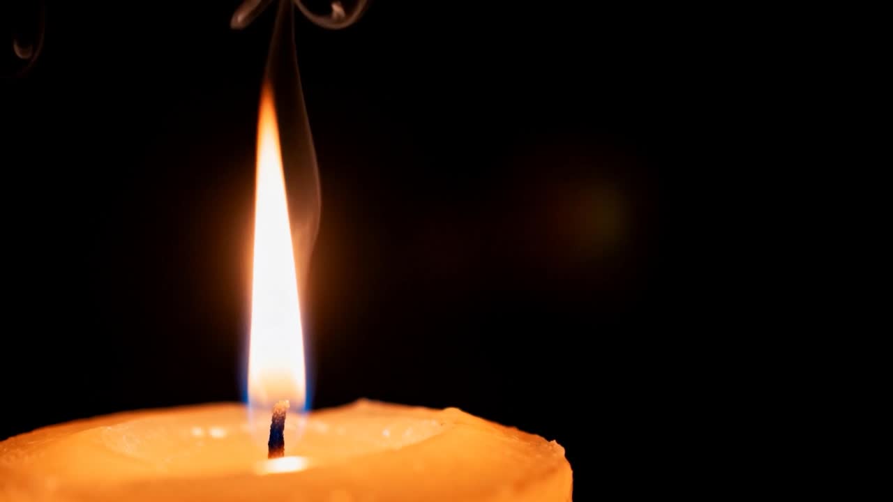Candela a colonna tremolante che reagisce a una corrente d'aria, si scioglie sullo stoppino e si spegne fumando, spazio per il testo