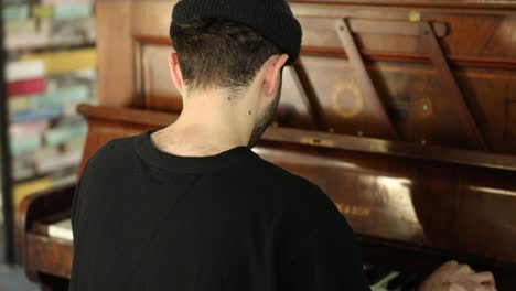primer plano de un hombre sentado en un piano de madera clásico y obras de teatro