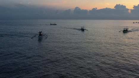 Panorámica-Aérea-De-Barcos-Jukung-Indonesios-En-Un-Tour-Por-El-Océano-Al-Amanecer-En-Lovina-Bali-Indonesia