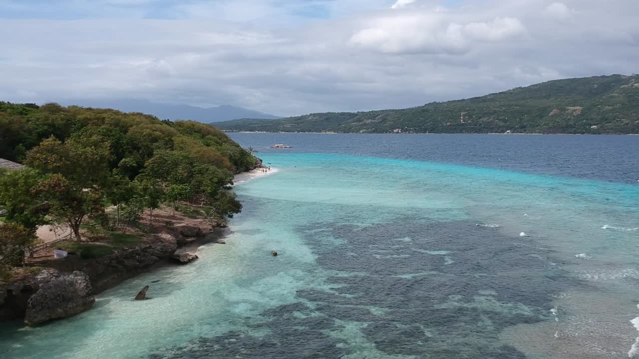 Riprese drone di acqua blu cristallina e onde sulla riva di una spiaggia a Cebu, Filippine-9