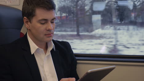 young businessman working with pad in the train