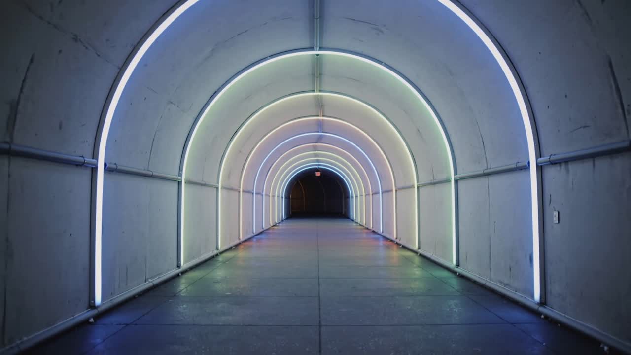 カメラがアーチ状のトンネルへ接近し、赤い標識が現れ、LEDリングが色を変えていく。