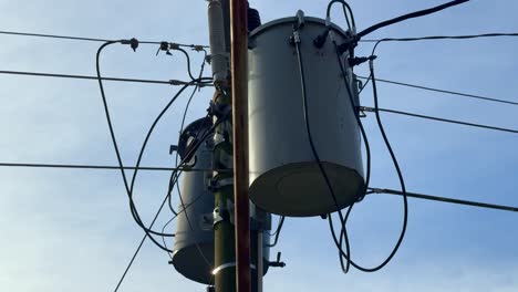 high-voltage transformers and electric cables on a power pole, illustrating rural or urban electrical utility systems