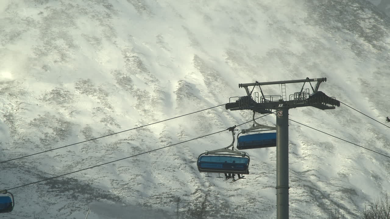 Una seggiovia trasporta sciatori sulle piste di Tatranska Lomnica, con gli Alti Tatra sullo sfondo.