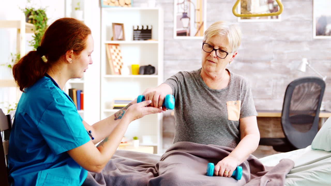 fotografía reveladora de una enfermera ayudando a una anciana a recuperar sus músculos
