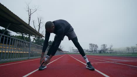 man stretching on a track