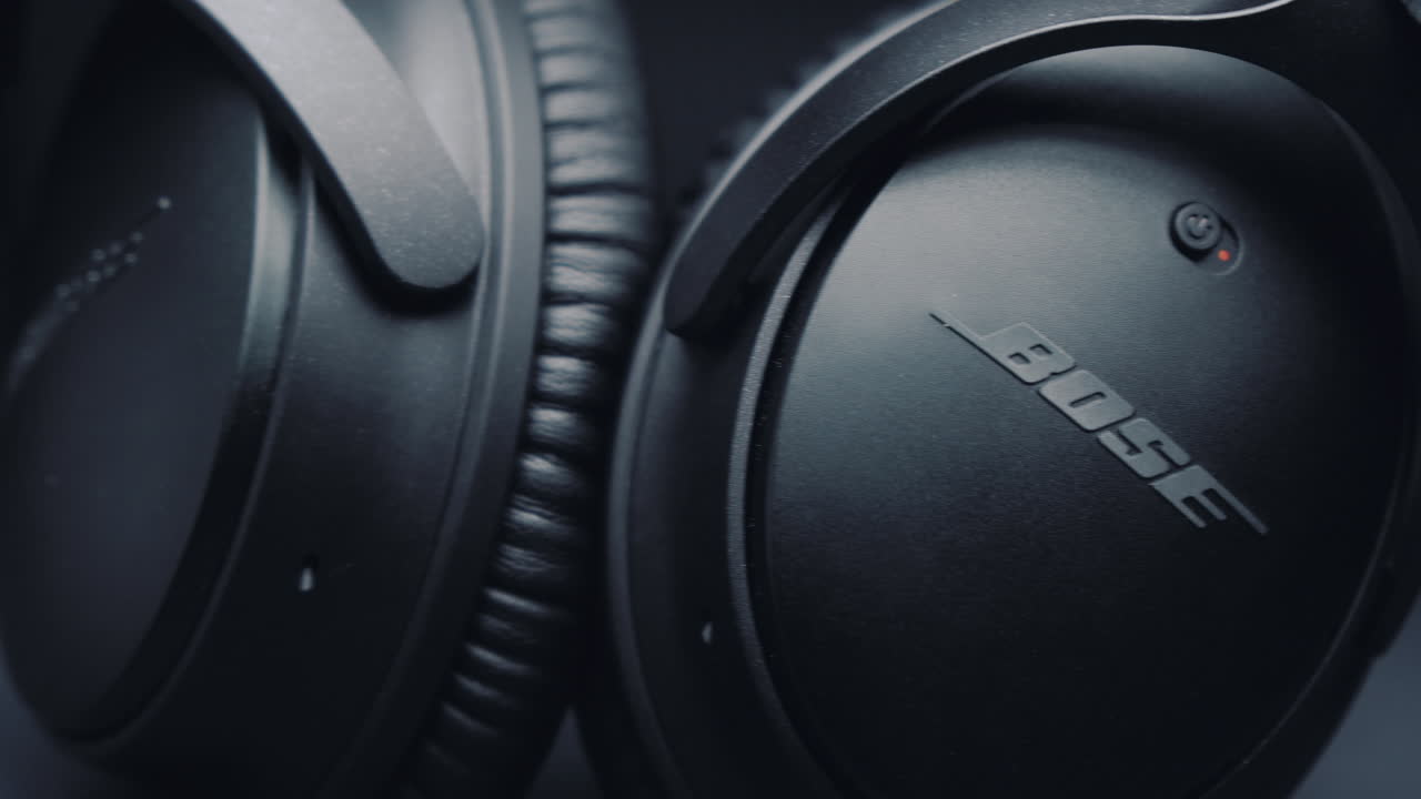 Detail of black headphones BOSE on a pure gray background. Camera movement from left to right.