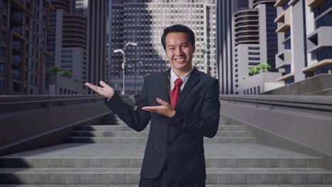 an asian business man showing open hand palm while standing in city