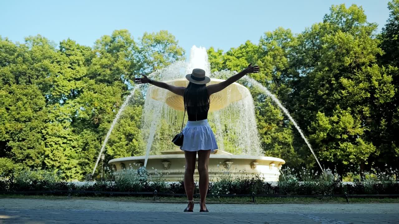 Philosophical cinematic moment of freedom at fountain in Warsaw Saxon Garden