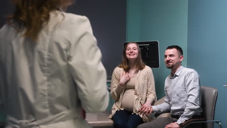 gynecologist approaches her pregnant patient and her husband in the medical consultation and informs them of the results of the ultrasound 1