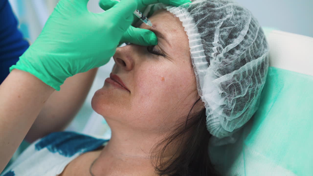 장갑을 입은 미용사는 여성에게 디스포트 주사를  ⁇ 니다.