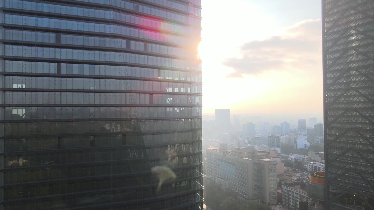 Elevação de drone de um grande edifício na Cidade do México com vista para o sol